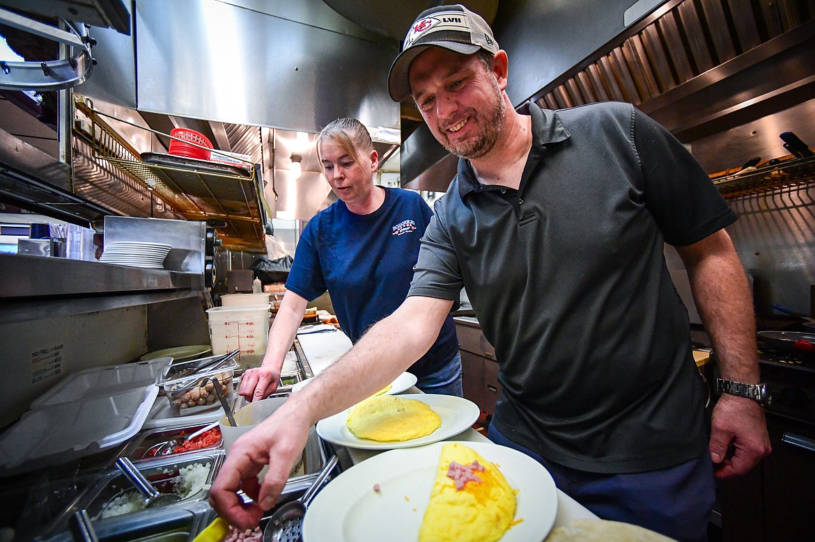 Longtime chefs Jeanine Jerome and Kris McEwen, who is the son of owner Tena Bowen, prepare meals in the kitchen at Bojangles Diner in Kalispell on Thursday, Dec. 19. McEwen has worked as a chef at Bojangles for nearly 20 years while Jerome has 10 years of service. (Casey Kreider/Daily Inter Lake)