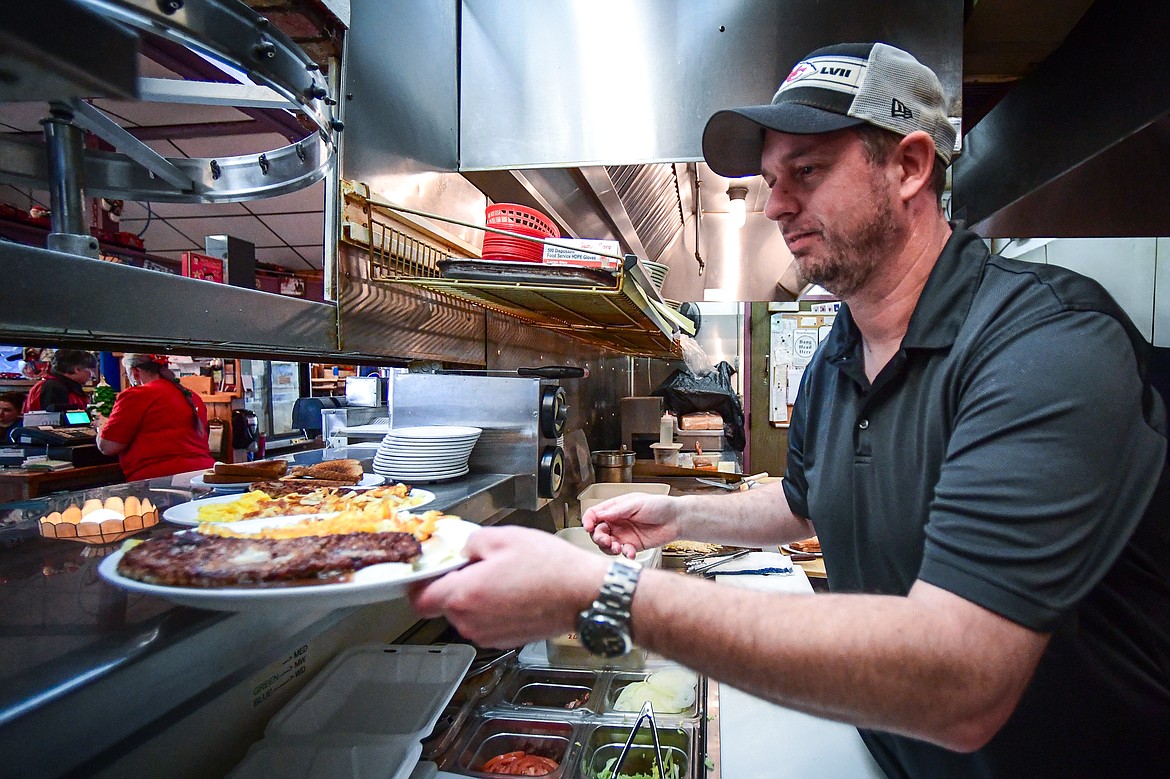 Chef Kris McEwen places orders in the window at Bojangles Diner in Kalispell on Thursday, Dec. 19. McEwen, son of owner Tena Bowen, has worked as a chef at Bojangles for nearly 20 years. (Casey Kreider/Daily Inter Lake)