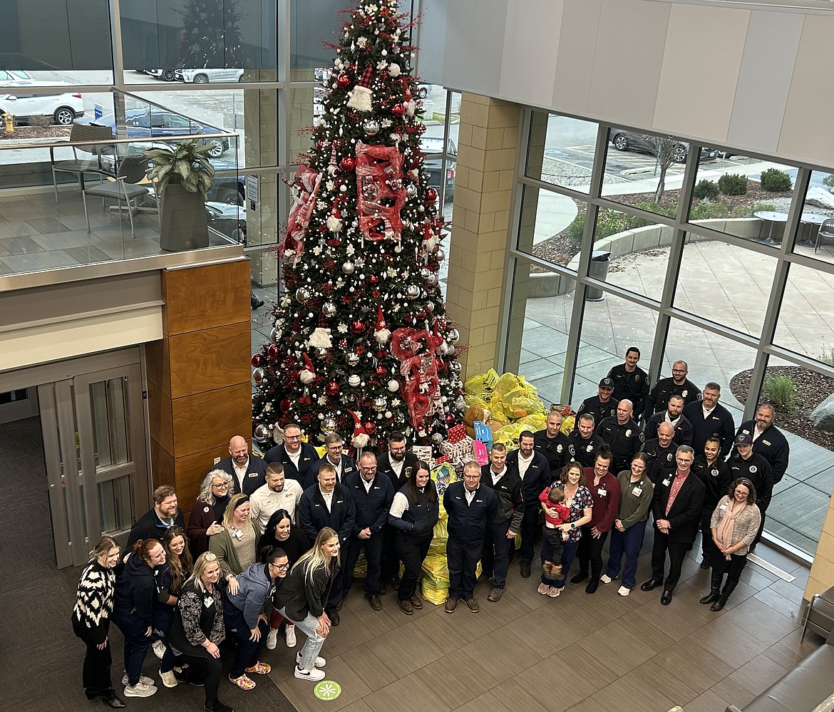 Members of the Coeur d'Alene Police Department and Les Schwab Tire Center pose in the Kootenai Health lobby after delivering hundreds of toys on Thursday.