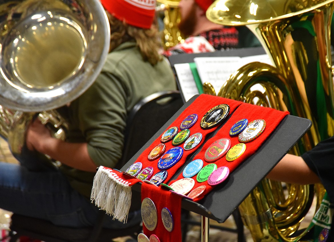 TubaChristmas was established in 1974 and a button for the worldwide concert event is released each year. Allen Slater, the organizer of the Kalispell event, displays his collection Dec. 16 at the concert at the Red Lion Hotel. (Heidi Desch/Daily Inter Lake)