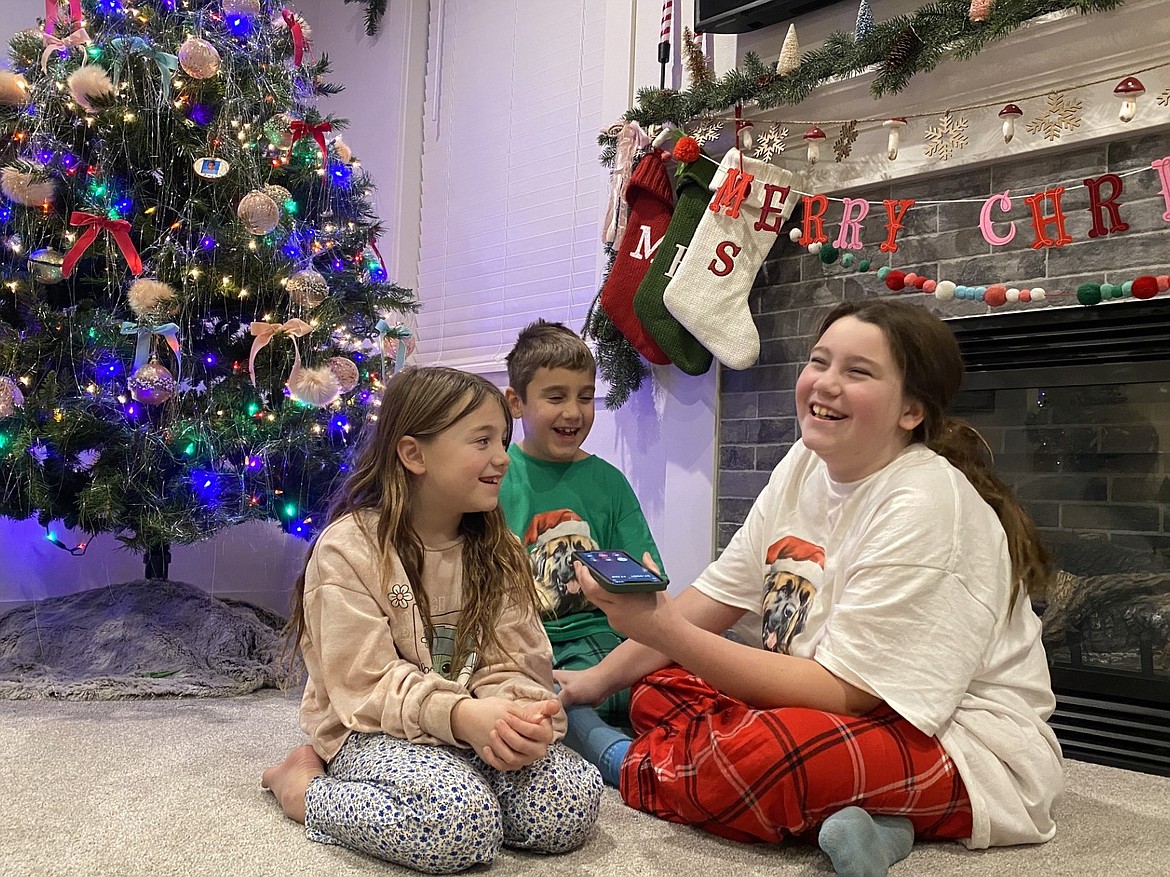 Hazel (7), Jude (7), and Scarlett (11) share a phone call with Santa at their Rathdrum home Tuesday night.