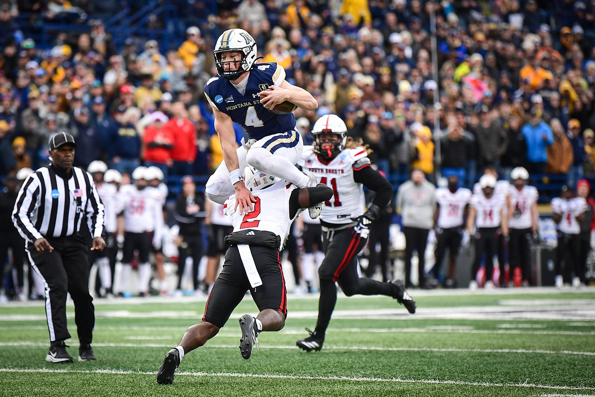 Montana State quarterback Tommy Mellott (4) is tripped up hurdling South Dakota defensive back Dennis Shorter (2) on an 11-yard run in the second quarter during an FCS semifinal game at Bobcat Stadium on Saturday, Dec. 21. (Casey Kreider/Daily Inter Lake)