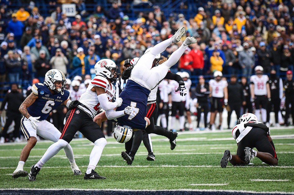 Montana State quarterback Tommy Mellott (4) is upended after hurdling South Dakota defensive back Dennis Shorter (2) on an 11-yard run in the second quarter during an FCS semifinal game at Bobcat Stadium on Saturday, Dec. 21. (Casey Kreider/Daily Inter Lake)