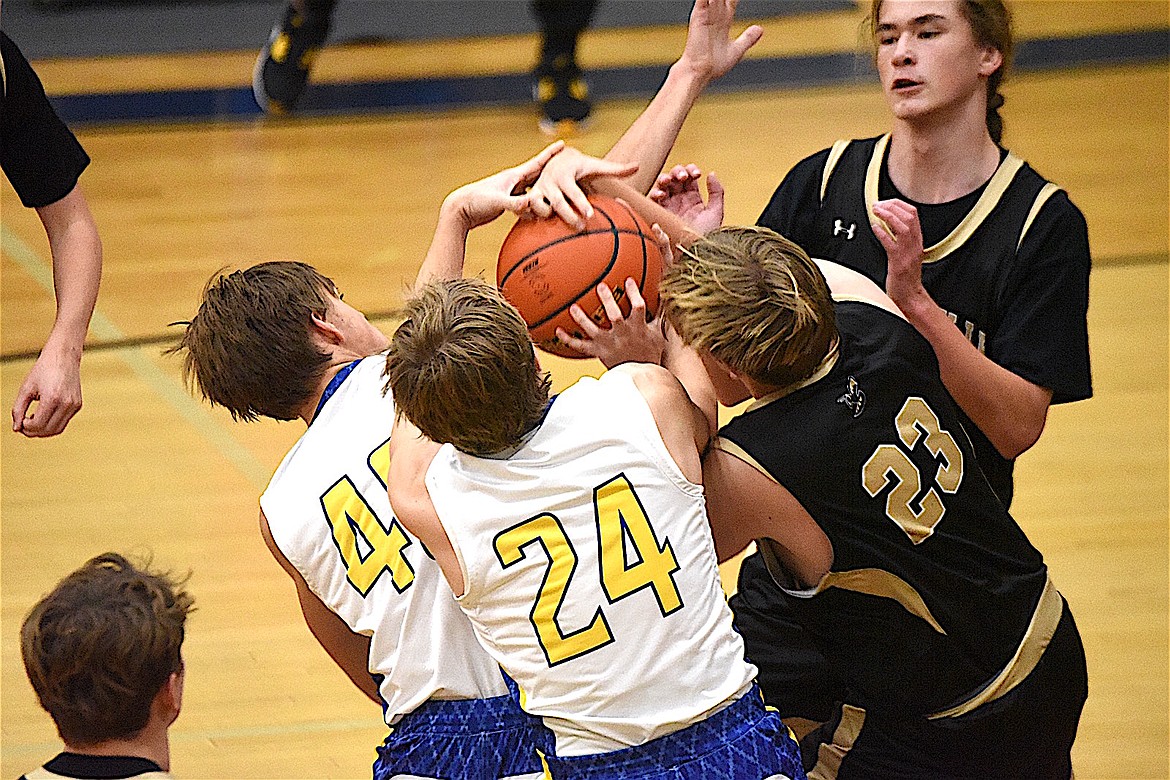 Libby's James Woody (40) and Alderic Martineau (24) battle Stevensville's Jake Gavlak for a rebound during their game Friday, Dec. 20, 2024. (Scott Shindledecker/The Western News)