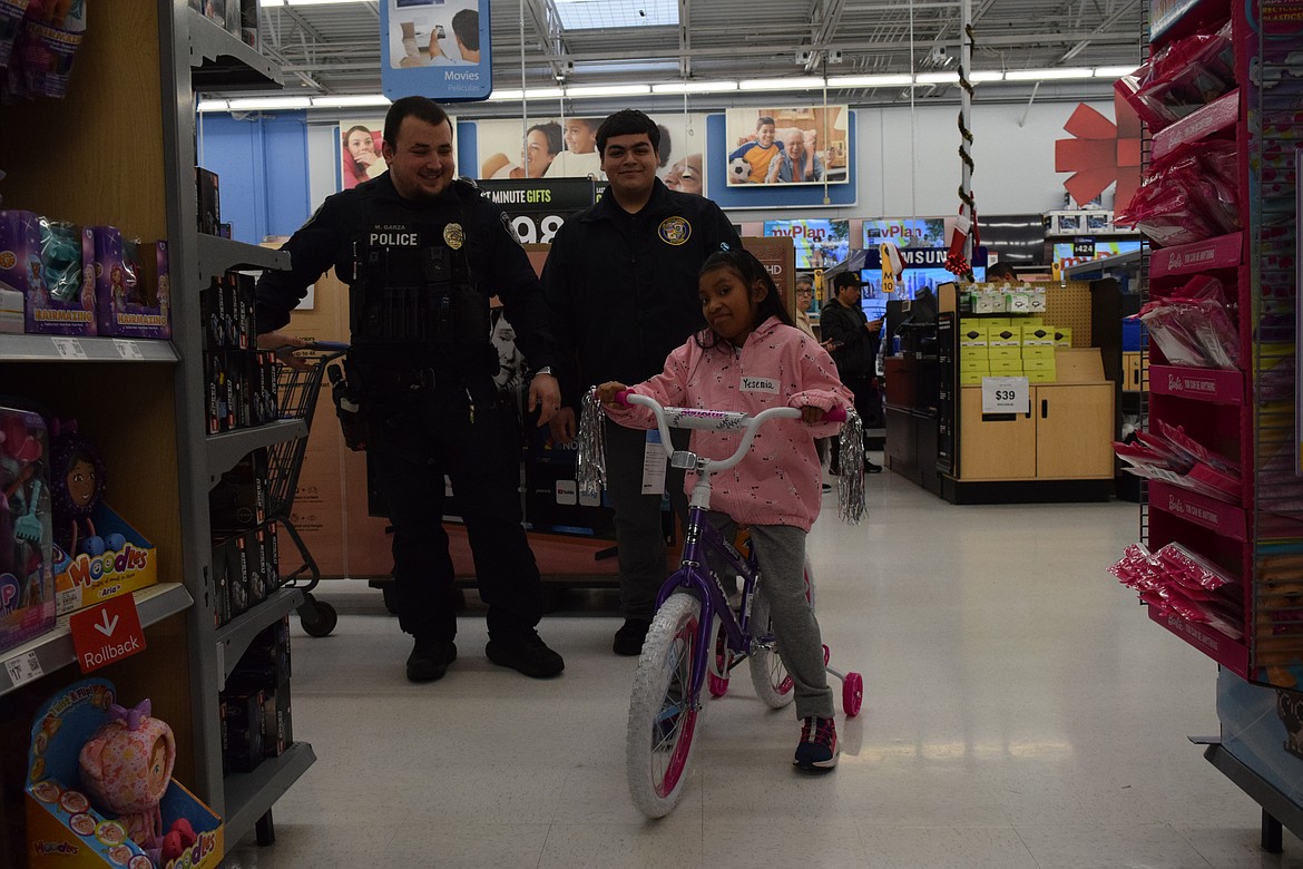 Yesania, one of the Shop with a Cop participants, tests out her final choice. Othello Police Department officer Martin Garza said she was pretty nervous but eventually she did tell them she wanted a bike and after careful deliberation she picked out a pink bike to match her jacket.