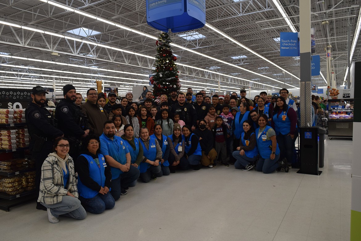 The Othello Police Department, Othello Police Explorers, Adams County Sheriff’s Office, Washington State Patrol, shoppers and Walmart staff pose for a photo at the beginning of the annual shop with a cop event.