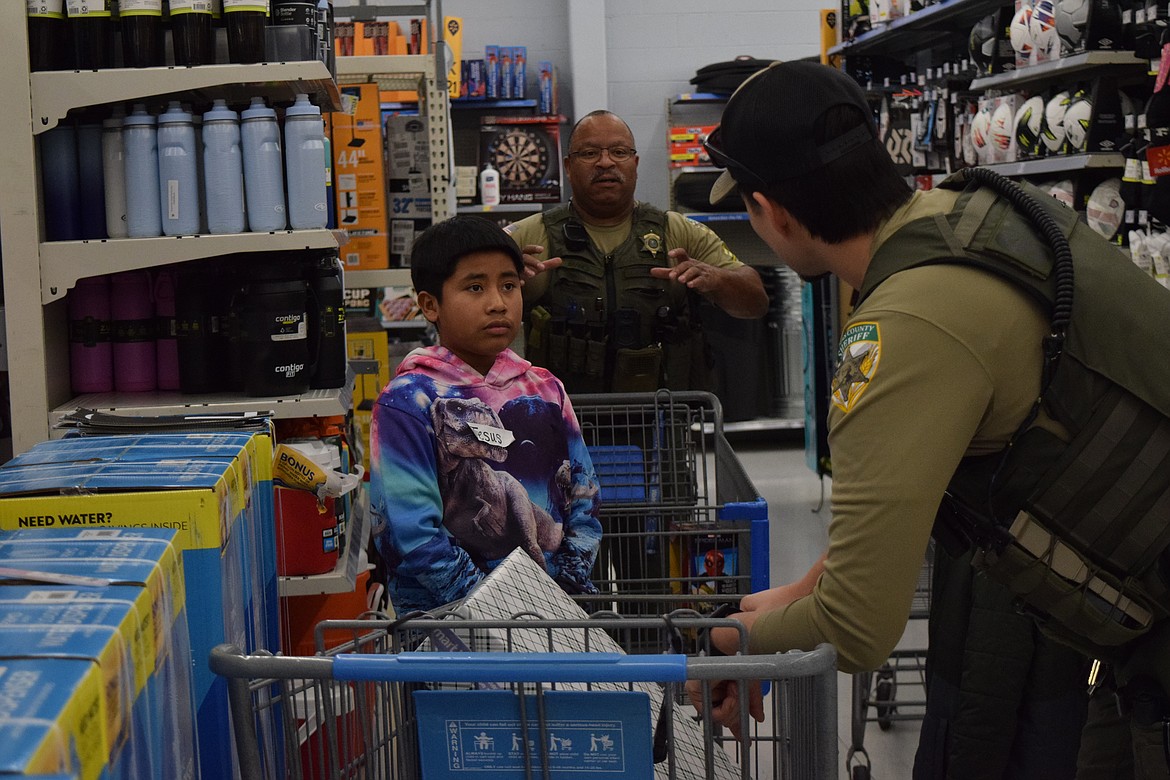 Jesus and two Adams County Sheriff’s Deputies discuss potential items to get with the remaining funds. Jesus alongside Levit (not pictured) decided a dining room table and chairs would be a good gift.