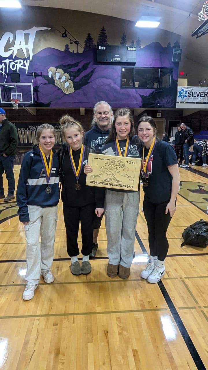 From left, Kylie Calderone, Nevaeh Therrien, Sofia Brown and Aubree Graves, alongside Bonners Ferry High head coach Michael Puckett, show off the hardware they earned at the George Wild Invitational.