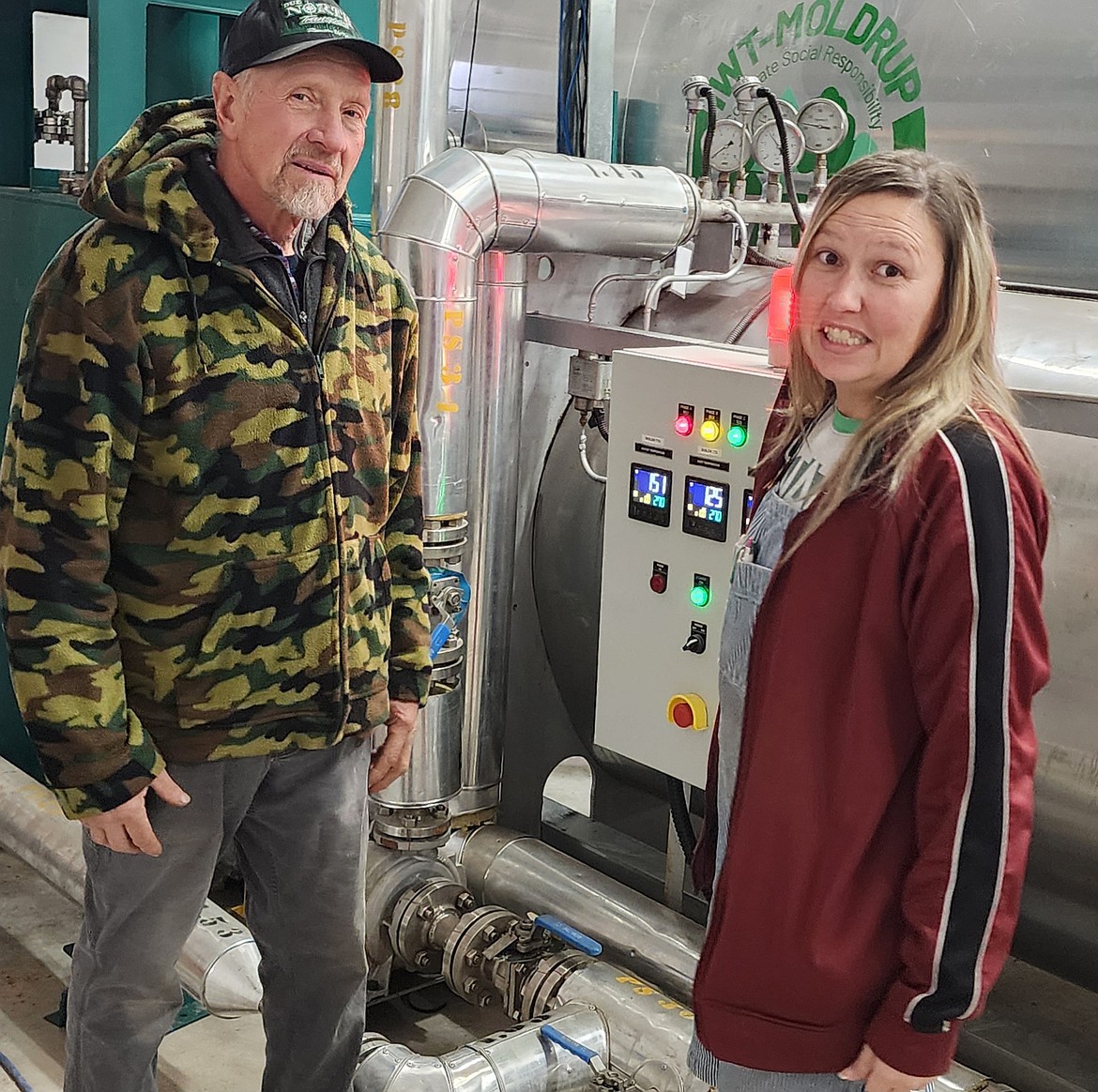 Tech Woods co-owner Marty Perkins and employee Cari Carter show off the massive new oven that sucks moisture out of wood at the plant in Ronan. (Berl Tiskus/Leader)