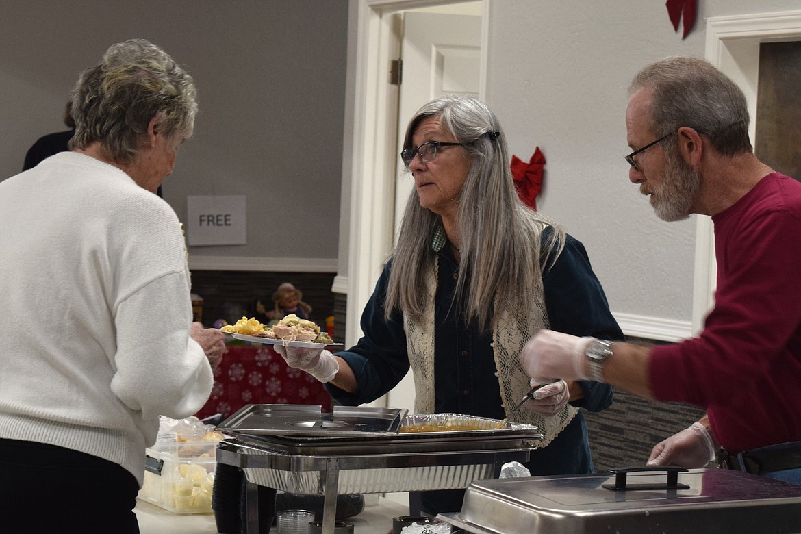 Volunteers hand out all the Christmas classics during Wednesday's free Christmas dinner at the Altar Church.