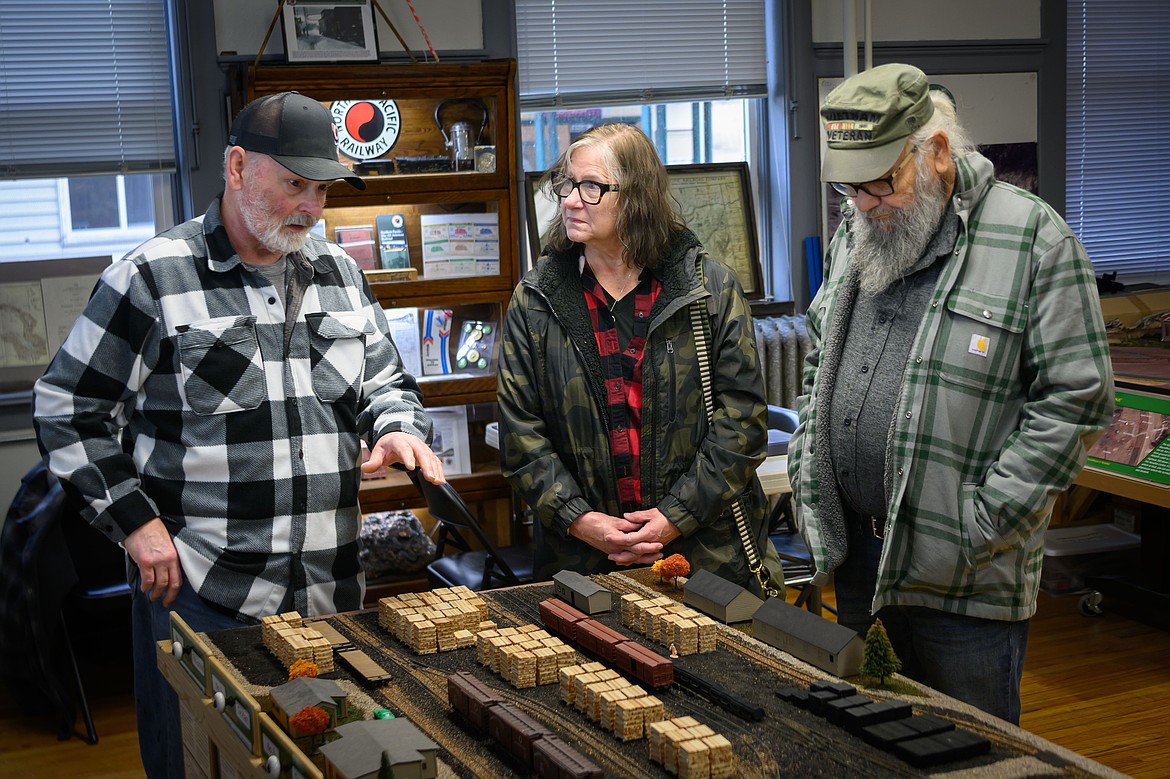 Paradise Center Board President Dave Colyer shows out-of-state residents Bob and Janet Resch a replica of the Paradise tie manufacturing plant. (Tracy Scott/Valley Press)