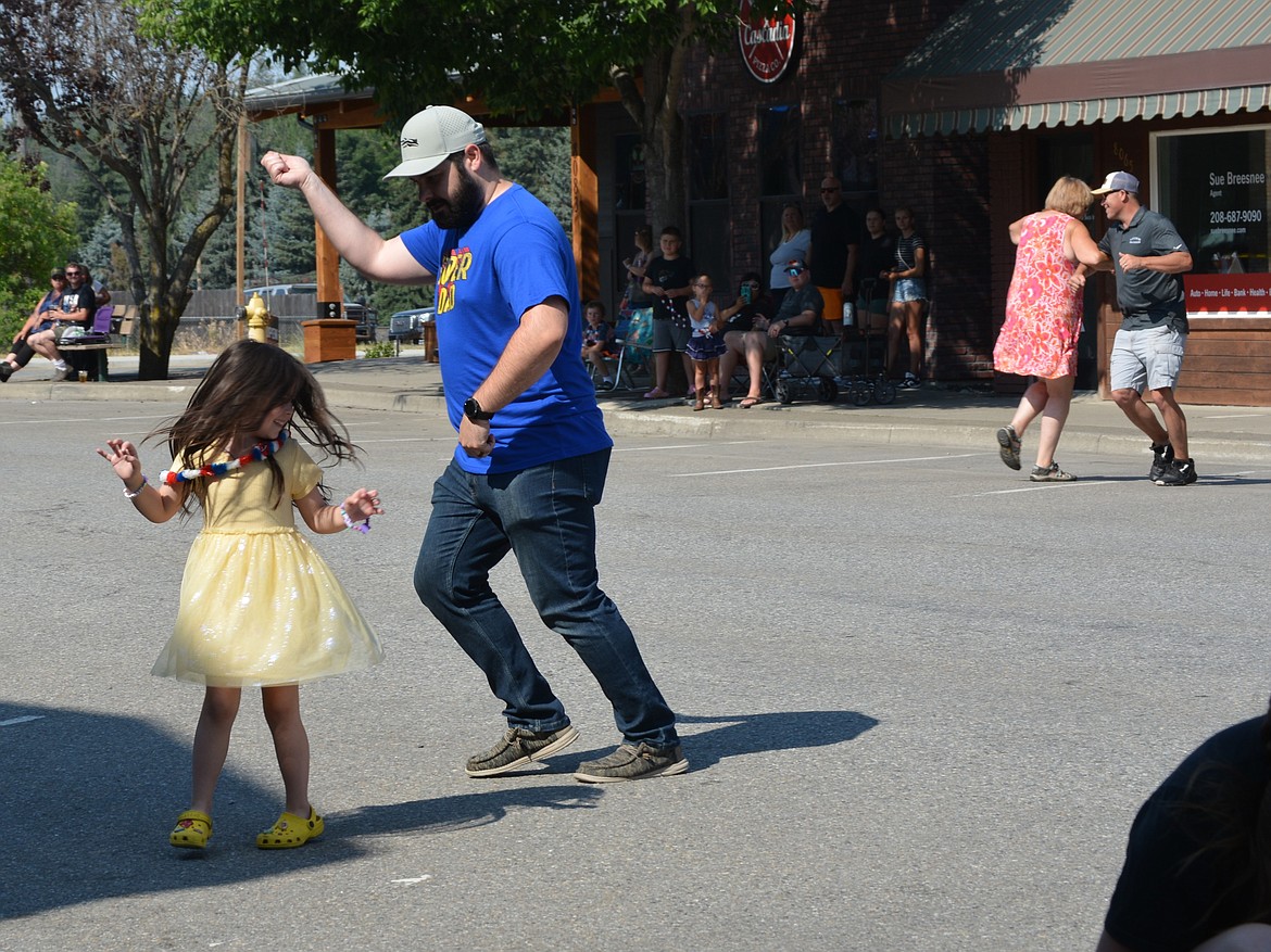 Natalie Duce spins as her father, Daniel Duce shows her the moves to the Cotton Eyed Joe dance at the Rathdrum Days parade.