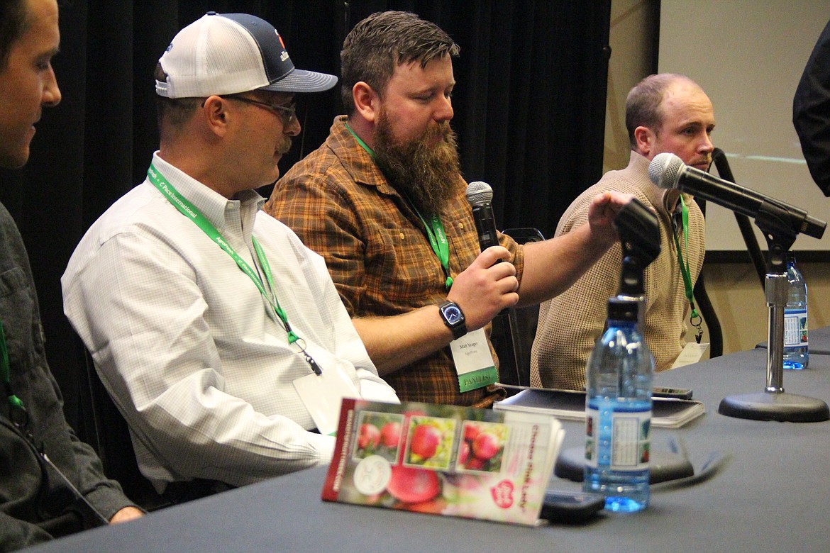 Matt Yaeger, right, makes a point during a panel on technology in the orchard at the Washington State Tree Fruit Association annual meeting Dec. 11. Panelists all have orchards, but also work in the ag business.