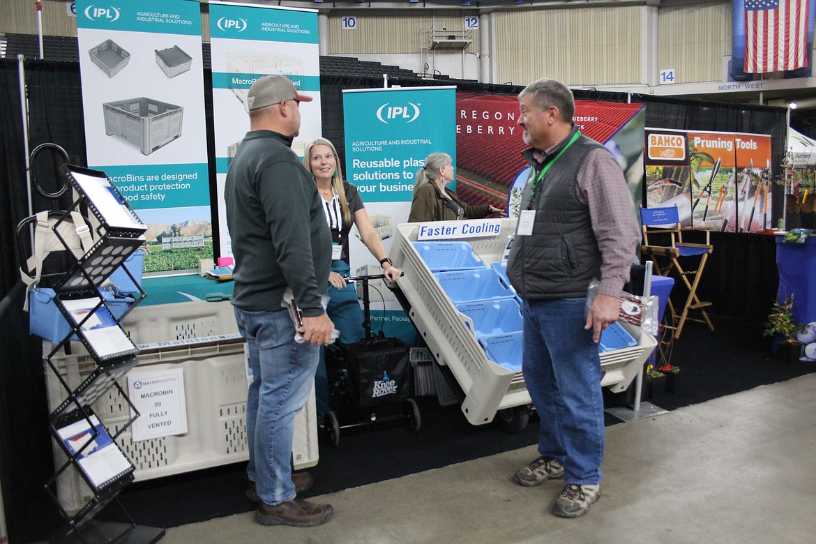 Attendees at the WSTFA annual meeting trade show talk with vendors. Getting the most out available technology was the subject of a grower panel Dec. 11.