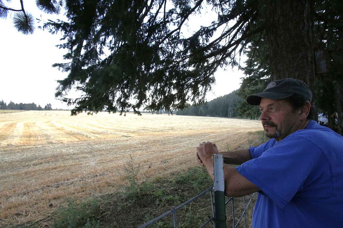 Laurin Scarcello looks out over the hay fields on his Rathdrum ranch as the sun begins to set July 25. His grandfather and great-uncles emigrated from Italy and established the ranch in 1910.