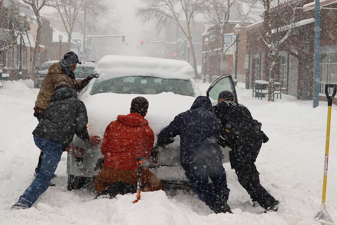 Men try to push a car free of snow on Lakeside Avenue in January.