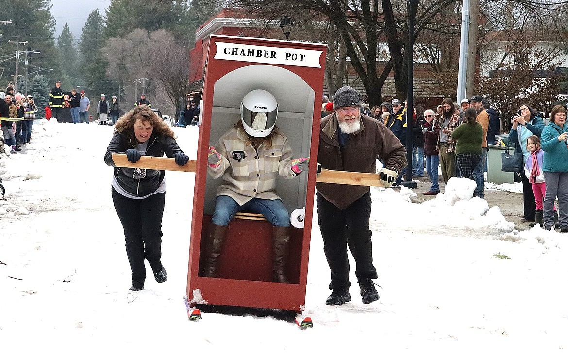 Joe and Carol Ferguson push daughter Catherine in the “Chamber Pot” entry in the Spirit Lake Winterfest Outhouse Races.