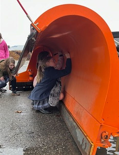 Classical Christian Academy students sign snowplows during a visit to the Coeur d'Alene Streets Department.