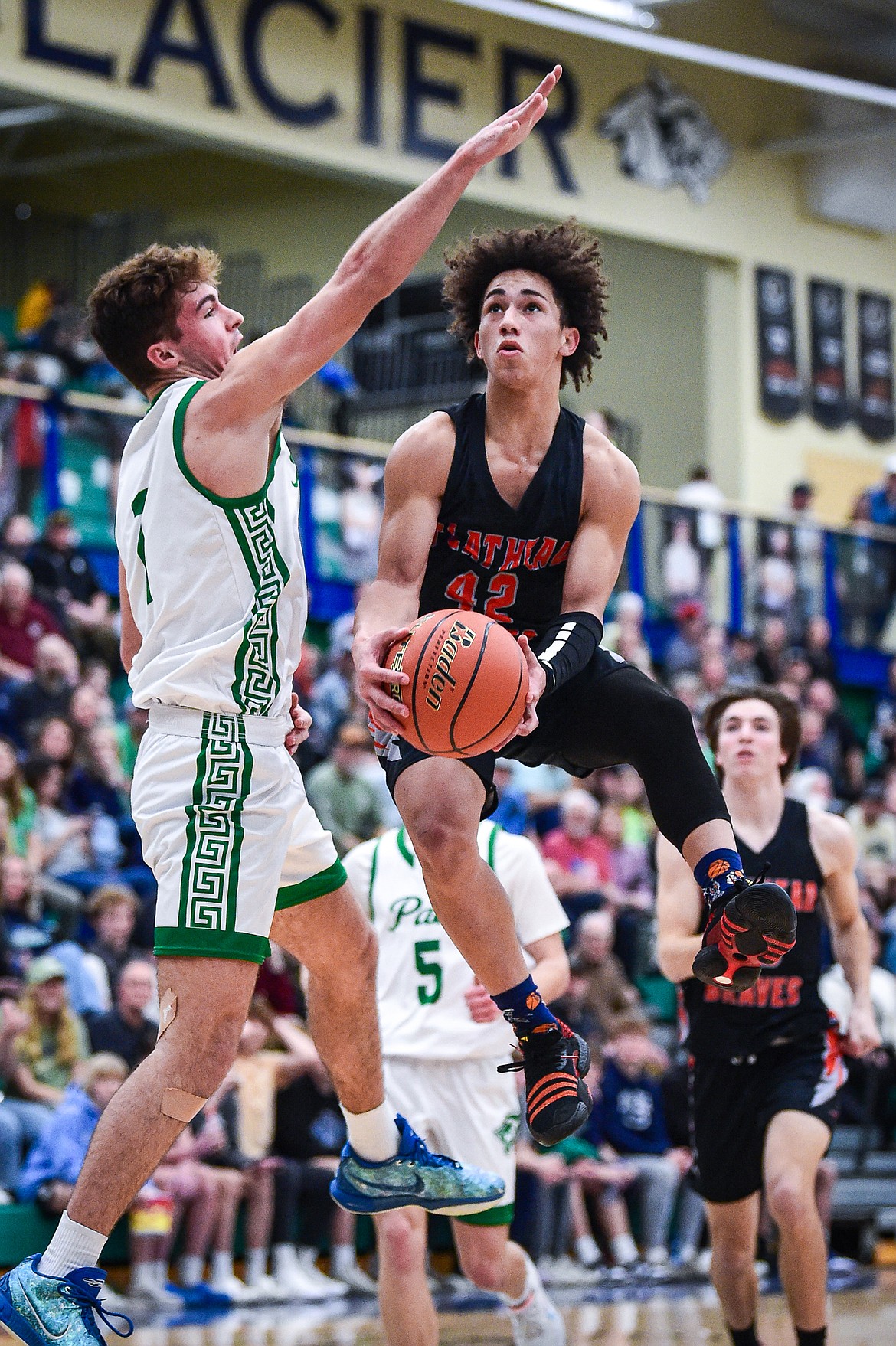 Flathead's Jordan Griffin (42) drives to the basket guarded by Glacier's Cohen Kastelitz (1) in the second half at Glacier High School on Thursday, Feb. 1. (Casey Kreider/Daily Inter Lake)