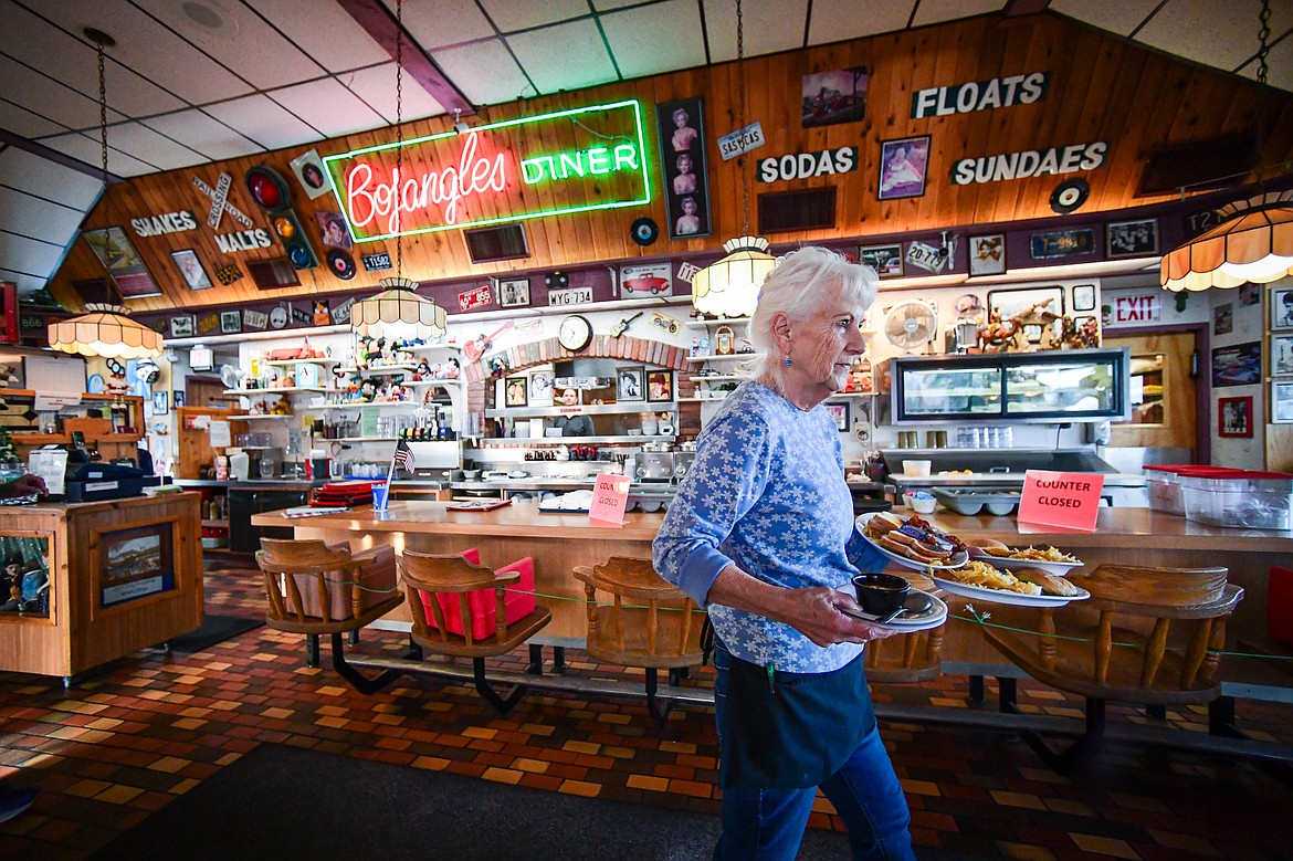 Sandi Gipe, who has been a server at Bojangles Diner in Kalispell for nearly 30 years, delivers an order to patrons inside the restaurant on Thursday, Dec. 19. (Casey Kreider/Daily Inter Lake)