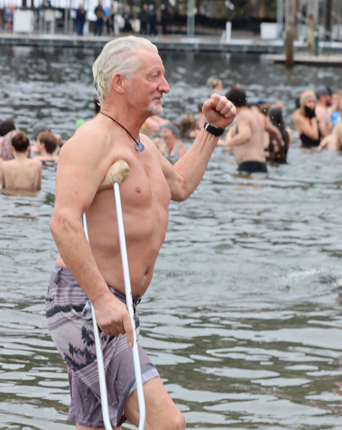 Paul Torgerson uses a crutch as he leaves Lake Coeur d'Alene after the Polar Bear Plunge on Wednesday.