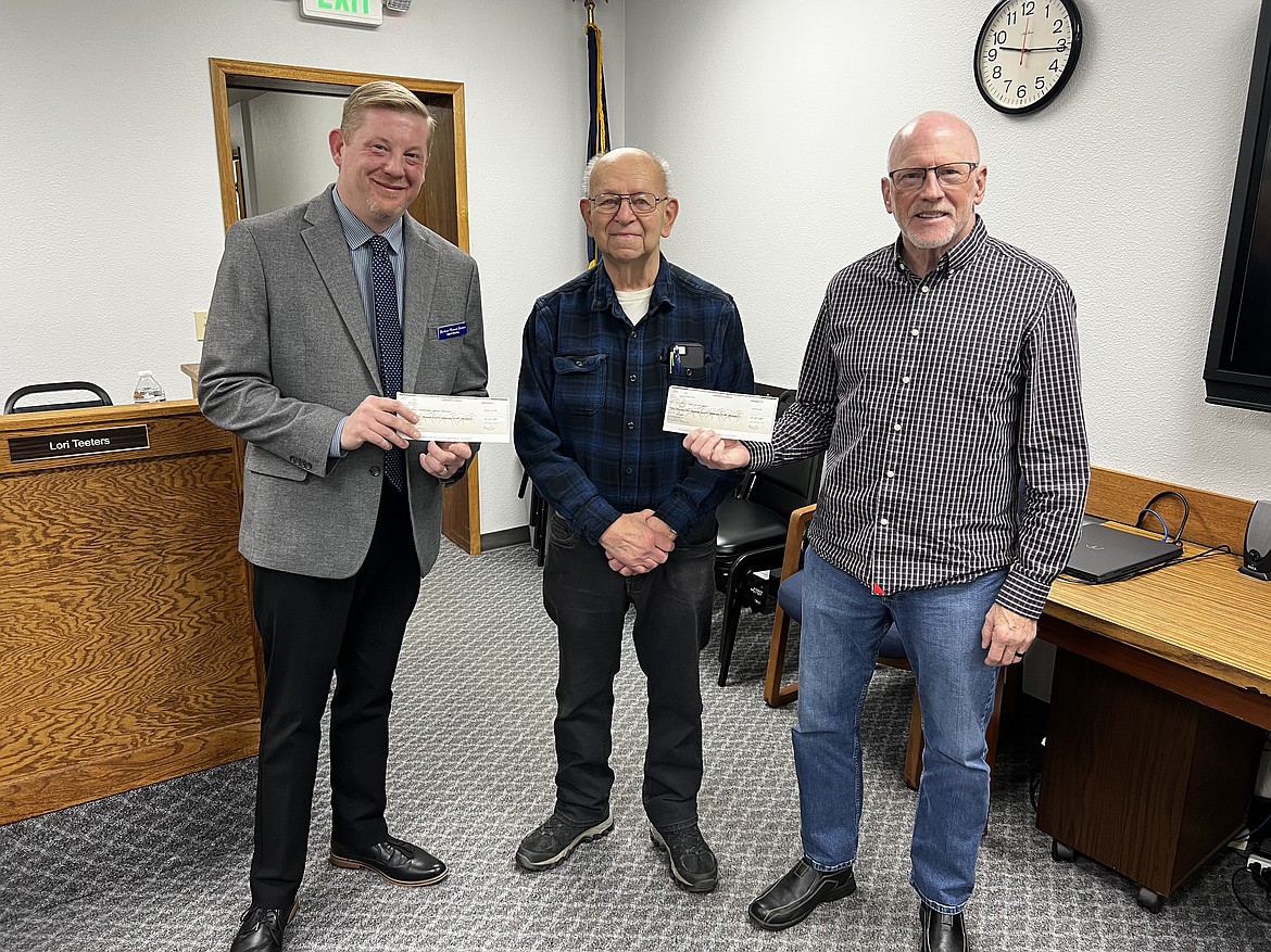 Shoshone Funeral Services owner Mark Owsley (left) and Kellogg Mayor Rod Plank (right) each received a check from the Kellogg Jaycees for their respective new lighted crosses at Shoshone Memorial Gardens and Greenwood Cemetery. Gary Temby (center) was a part of the Jaycees when they built and maintained the original crosses over 50 years ago.