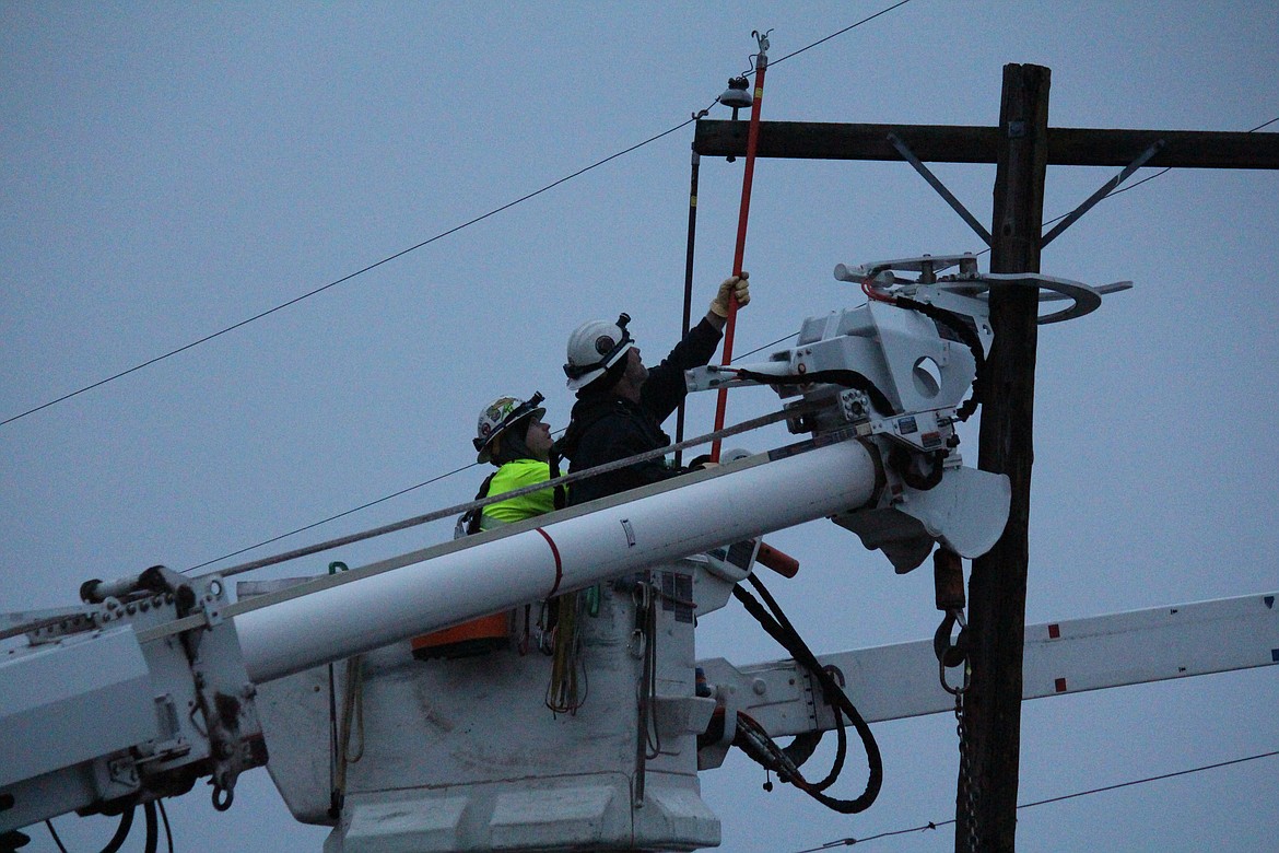 Grant County PUD line workers go about the tricky business of removing electrical wires from a broken power pole. In some instances, the lines are live when these replacements occur, resulting in the need for extra caution on the part of line workers.