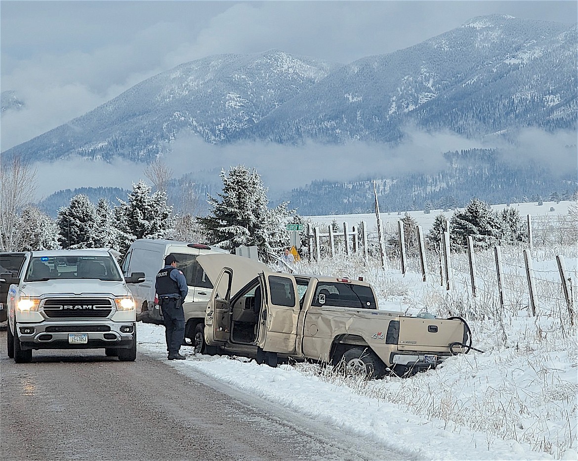 Officer inspects the truck driven by Codie James Dana that eventually landed in the ditch near the intersection of Skyline and Glover Road on New Year's Eve, after a high-speed chase through Polson. (Jeff Smith photo)