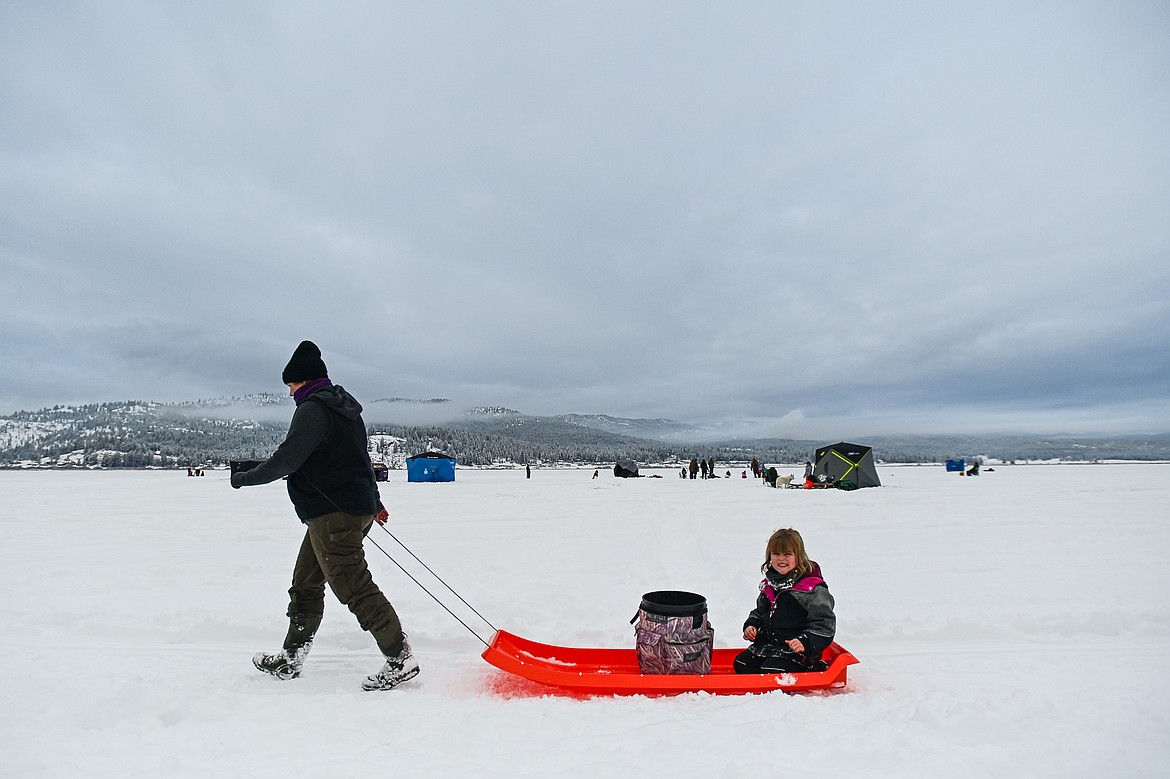 A young girl smiles as she is towed across the frozen surface of Smith Lake at the 53rd annual Sunriser Lions Ice Fishing Derby on Smith Lake in Kila on Saturday, Jan. 4. (Casey Kreider/Daily Inter Lake)