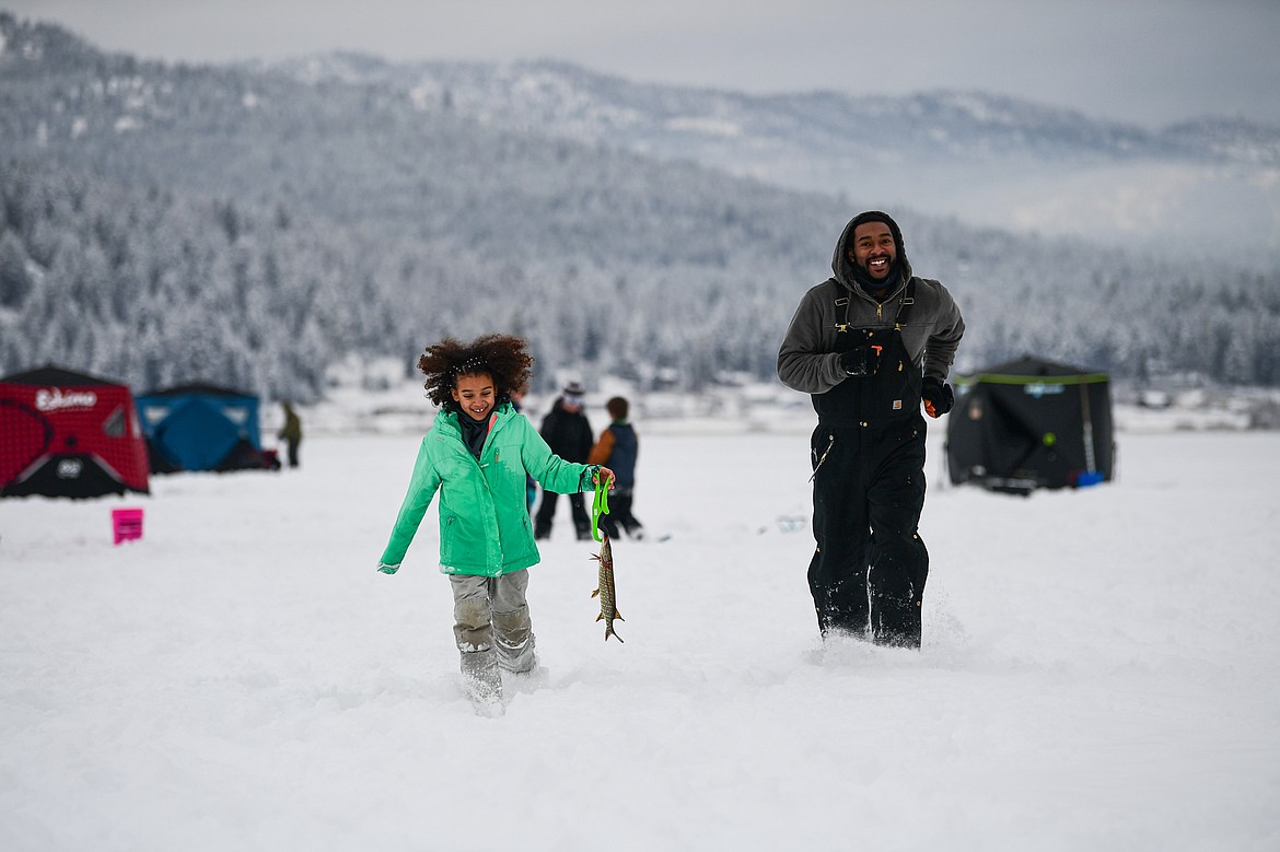 Nola and Tyler Mason carry a pike to shore to be measured at the 53rd annual Sunriser Lions Ice Fishing Derby on Smith Lake in Kila on Saturday, Jan. 4. (Casey Kreider/Daily Inter Lake)