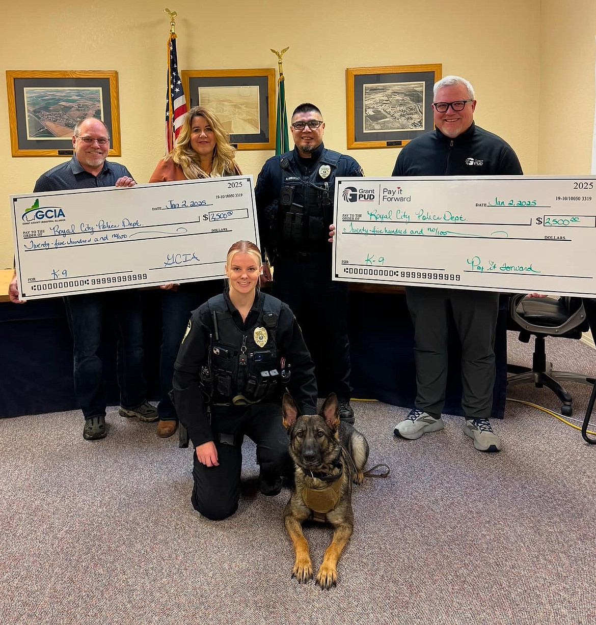 Chuck Sutton and Lisa Karstetter, left and second from left, president and treasurer of the Grant County Industrial Alliance, and Chuck Allen, right, senior manager of external affairs for the Grant County PUD, present donations to Royal City Police Chief Rey Rodriguez, center, for the department’s K-9 program. The donation bought a ballistic vest for the city’s new K-9, Ollie, shown with her handler Hannah Soelter in front.