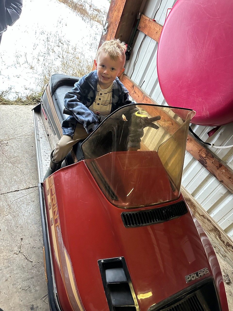 Daxton Keenen, 6, son of Brogan Keenen sits on his 1986 Polaris snowmobile that will be entered in the Vintage Snowmobile Show Saturday, January 18 in Haugan, Montana. 2025 Winterfest is a new family event this year from the Montana Nightriders Snowmobile Club. (photo by Brogan Keenen)