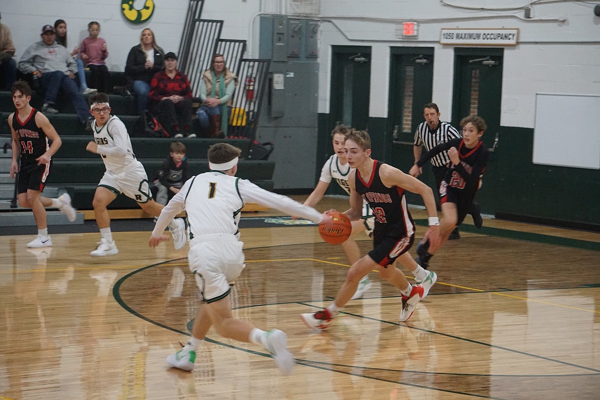 Hot Springs sophomore forward Ben Aldridge tries to dribble past St. Regis senior Ayden Rael (1) during their game this past Thursday in St. Regis. (Photo by Tammy McAllister)