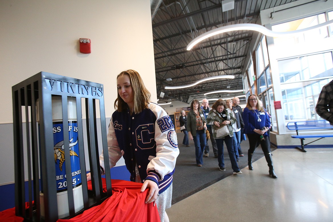 Senior Eva Brown wheels the Class of 1950 time capsule into Viking Court while accompanied Tuesday by relatives of the late Ray Capaul, who served as the 1950 Coeur d'Alene High class president.