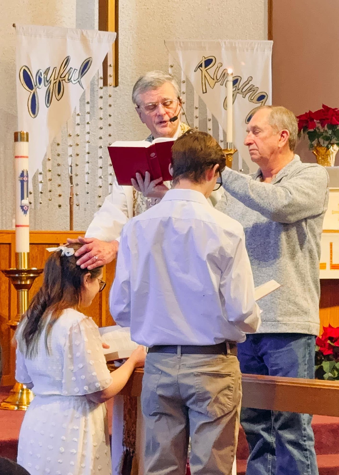 Pastor Walter Klockers, left, assisted by Church Council President Scott Staples, confirms two students at Immanuel Lutheran Church in Moses Lake.