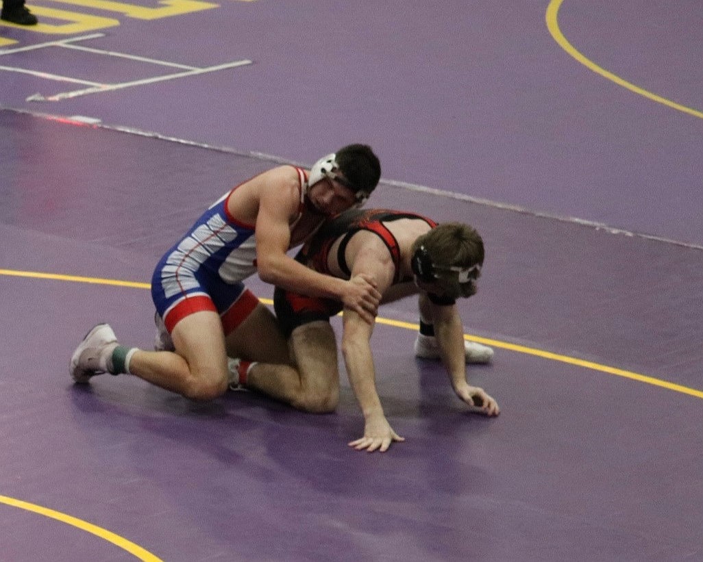 Superior sophomore Turner Milender (top, blue) works for a takedown on Plains-Hot Springs' senior John Waterbury during their 157-pound championship match at the Cut Bank Booster Invitational this past weekend.  Waterbury won 15-12.  (Photo by Kami Milender)