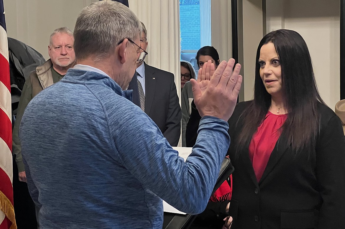 Commissioner Melissa Cowles is sworn in by Commissioner Dave Dose on Monday.