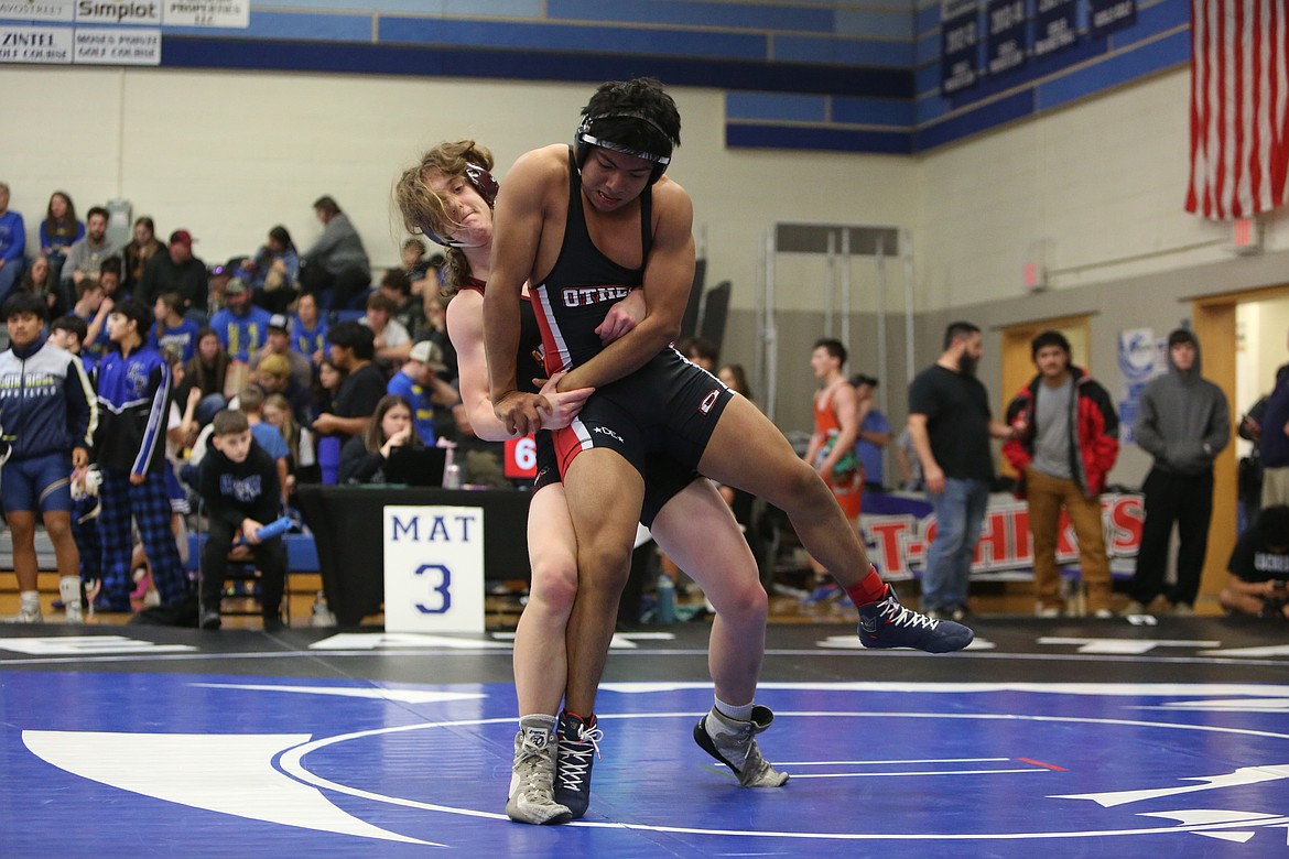 Moses Lake junior Blayne Richards, background, takes down Othello junior Luis Feliciano, foreground. Feliciano won the match and took fourth in the 157-pound class.