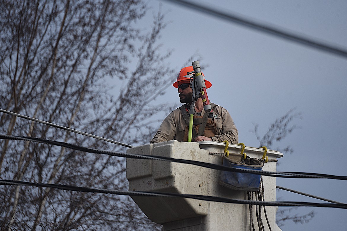 A Flathead Electric worker goes up in a bucket truck to shut off power at the scene of an apartment fire Tuesday afternoon on Main Avenue in Libby. (Scott Shindledecker/The Western News)