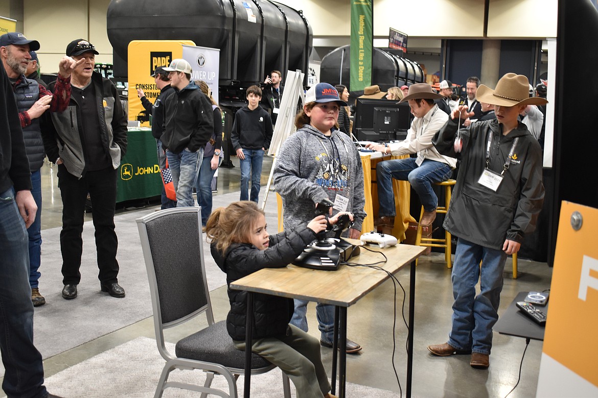 Four-year-old Kamryn Schroeder, 4, from Wilbur, Washington attempts to land a crop duster in a video game-style simulator at last year’s Spokane Ag Show.