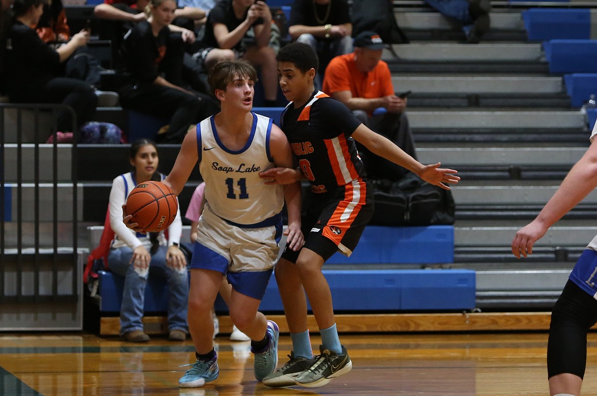 Soap Lake junior Logan Northup, left, looks for a teammate to pass the ball to during a Dec. 3 game against Republic.