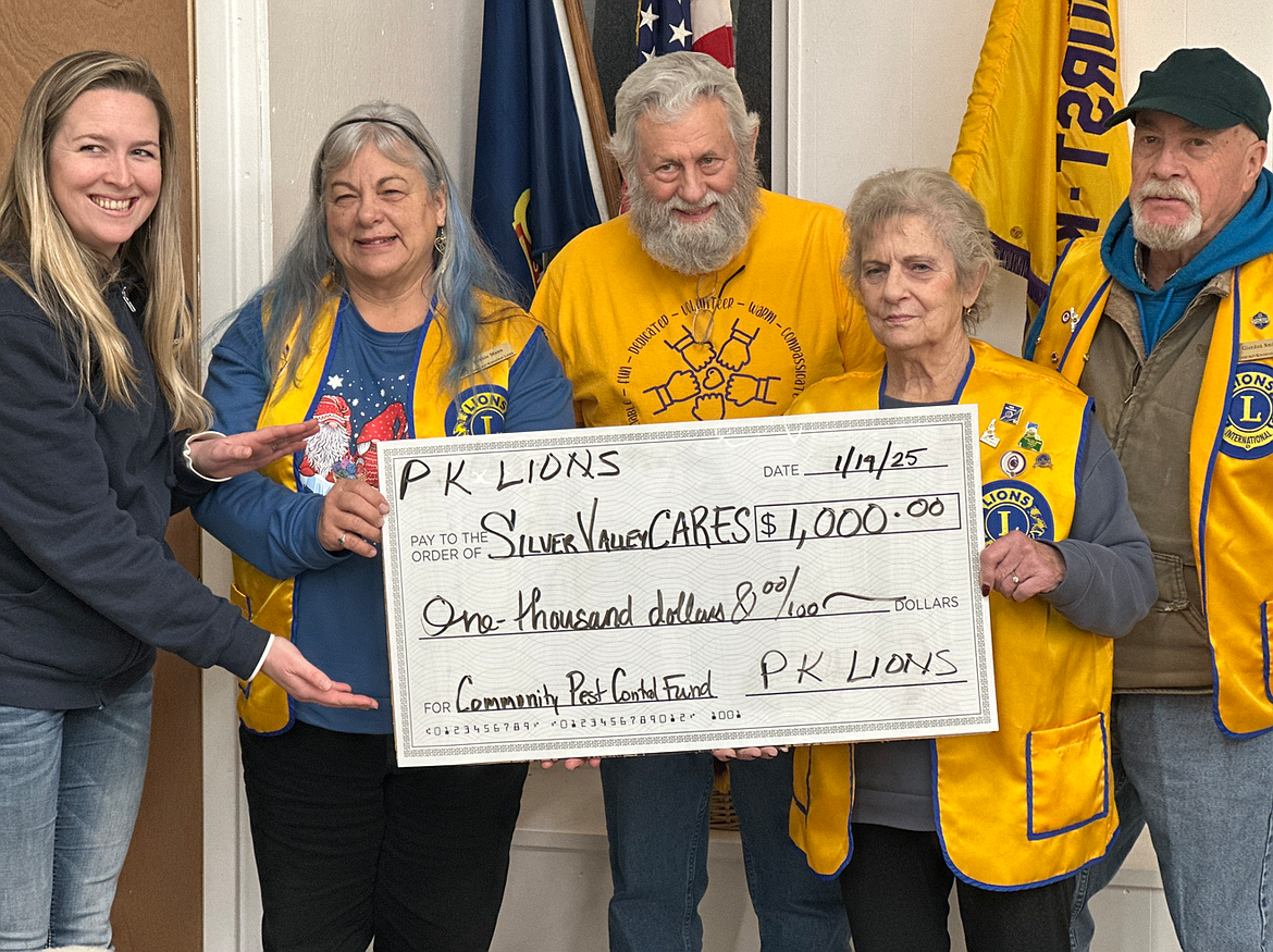 Siobhan Curet accepts a check for $1,000 from members of the PK Lions Club on behalf of Silver Valley CARES. The money is being donated to the group's Community Pest Control fund.