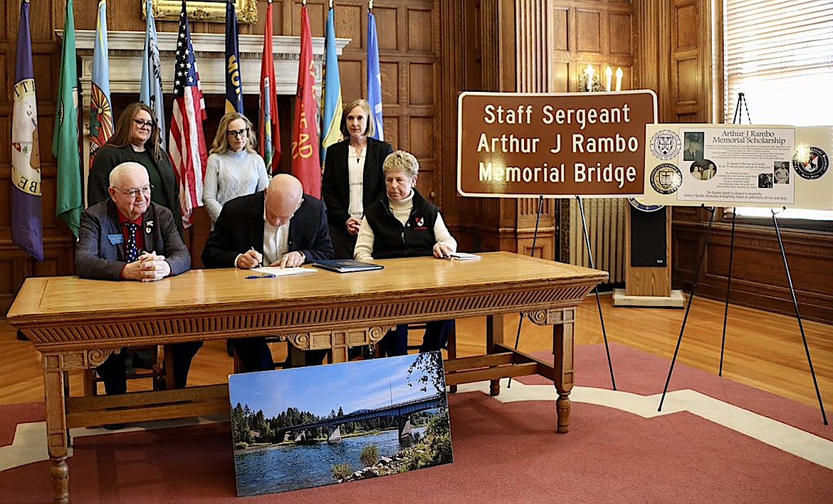 Montana Gov. Greg Gianforte, center, signs Senate Bill 59, naming the bridge over the Kootenai River in Libby after U.S. Army Staff Sgt. Arthur J Rambo. Rambo died in the Vietnam War on Thanksgiving Day, 1969. To Gianforte's right is Rambo's sister, Patty Rambo, and to his left is Montana Sen. Mike Cuffe, who introduced the bill. (Courtesy photo)