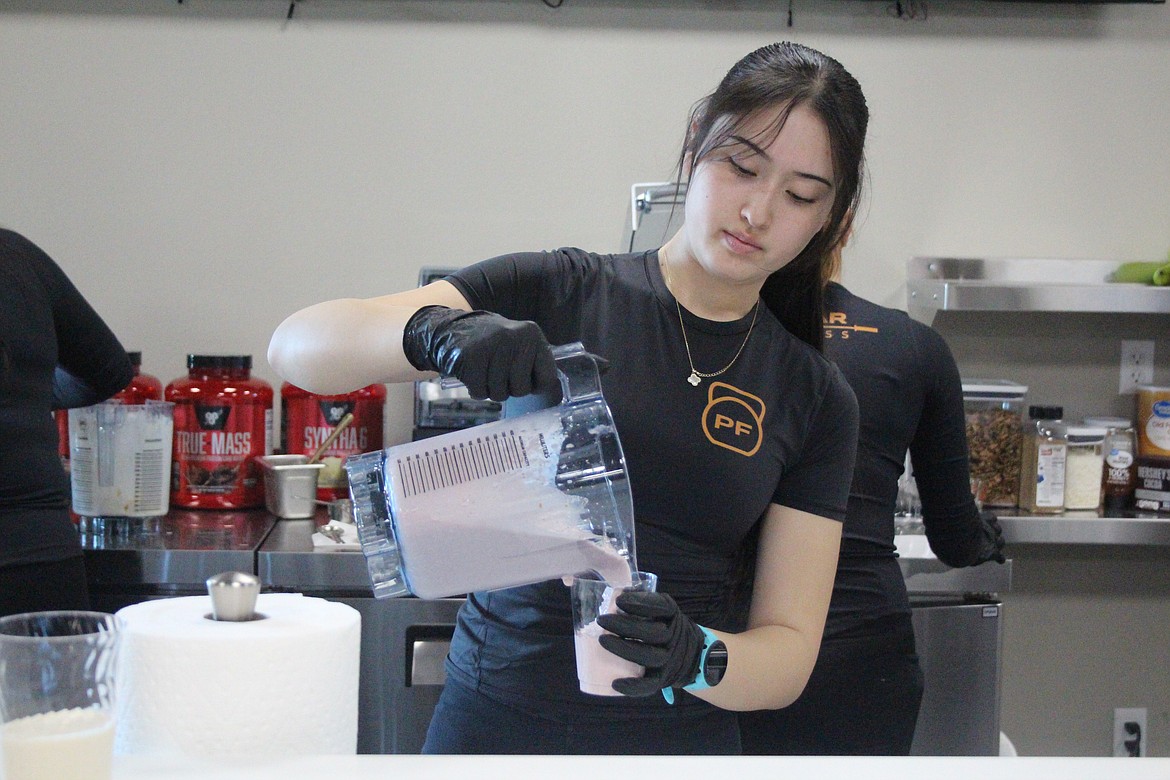 A Pillar Fitness employee pours smoothies at the juice bar during the grand opening.