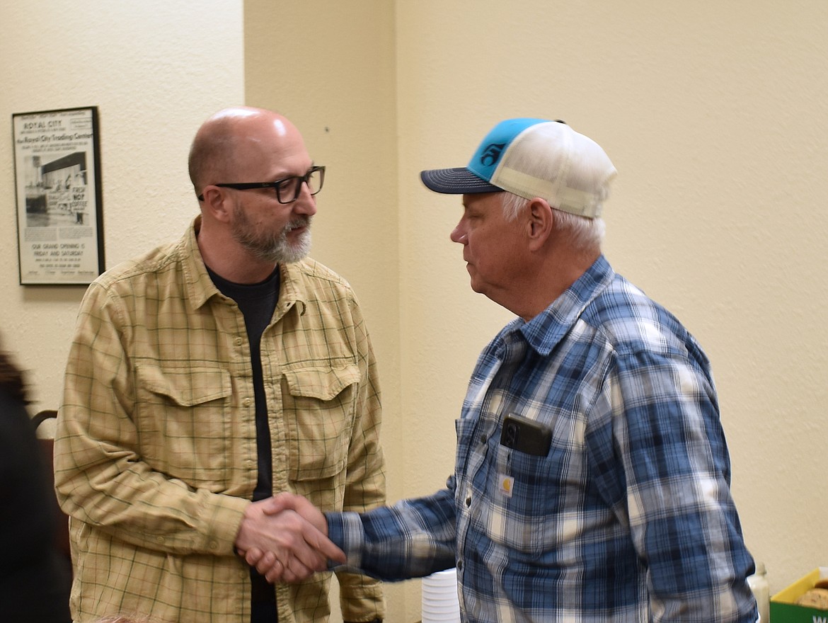 Jake Hollopeter, an engineer with Anderson Perry, congratulates John Lasen on his retirement as Royal City’s public works director.