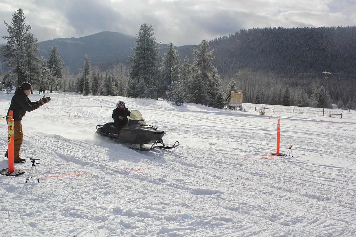 Tom Mullins from St. Ignatius, Montana is the unofficial president of the unofficial vintage snowmobile group, crosses the finish line in the individual timed event. Mullins enjoys the vintage sleds because he feels they are the forerunners of making family snowmobiling such a wonderful activity in the winter. (Monte Turner/Mineral Independent)