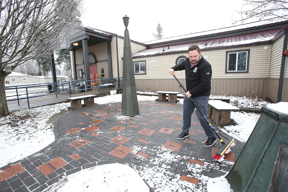 Damon Wood brushes off engraved pavers in the newly installed patio Jan. 8 at Lake City Playhouse. The theater will again sell commemorative bricks as a fundraiser beginning with the Jan. 31 opening of "Rent."