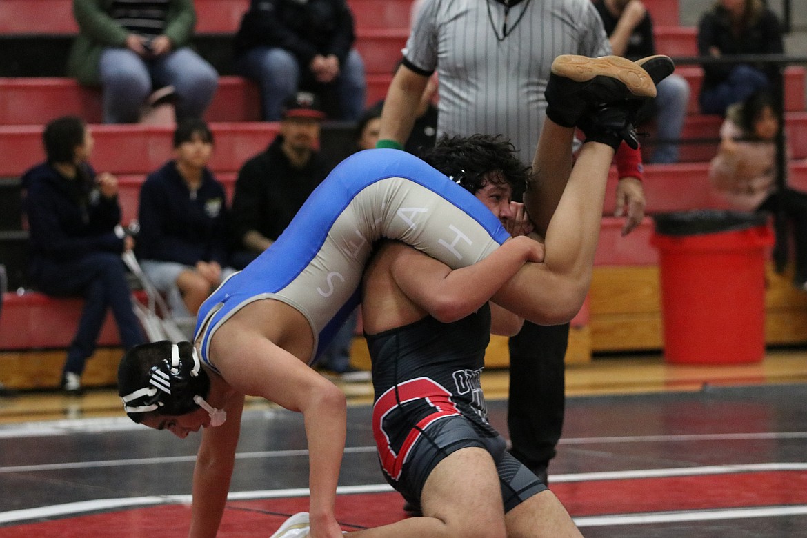 Othello’s Angel DeLeon III, in black, lifts his opponent during Wednesday’s dual against Selah.