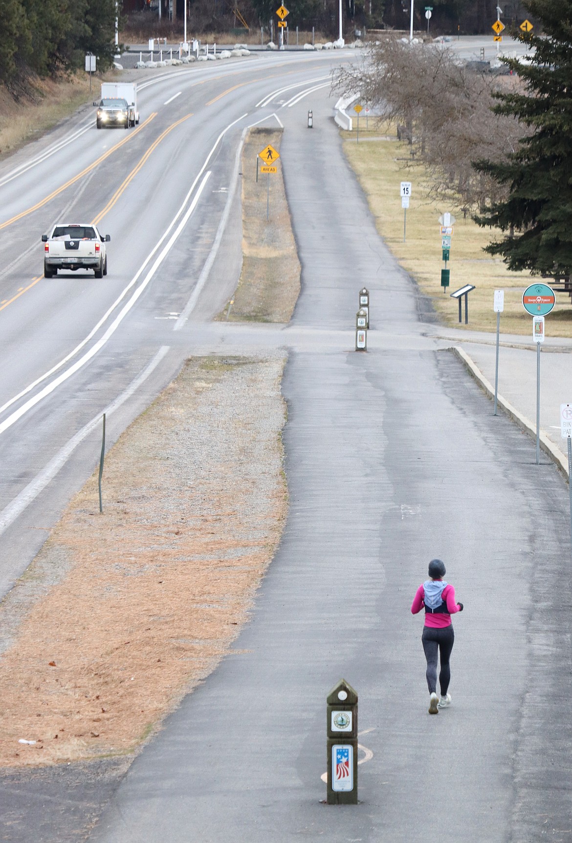 A runner makes their way on the North Idaho Centennial Lake next to Coeur d'Alene Lake Drive by the Silver Beach Marina on Thursday afternoon.