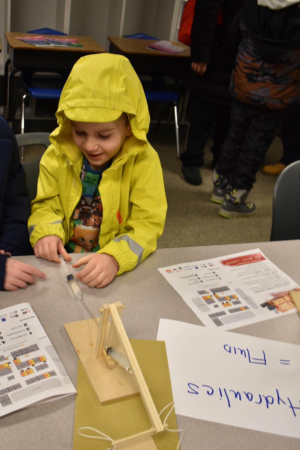 Hunter Ketterer, 4, pushes water into a hydraulic tube to raise a wooden crane at the NCW Tech Alliance STEM event at Garden Heights Elementary School Thursday.
